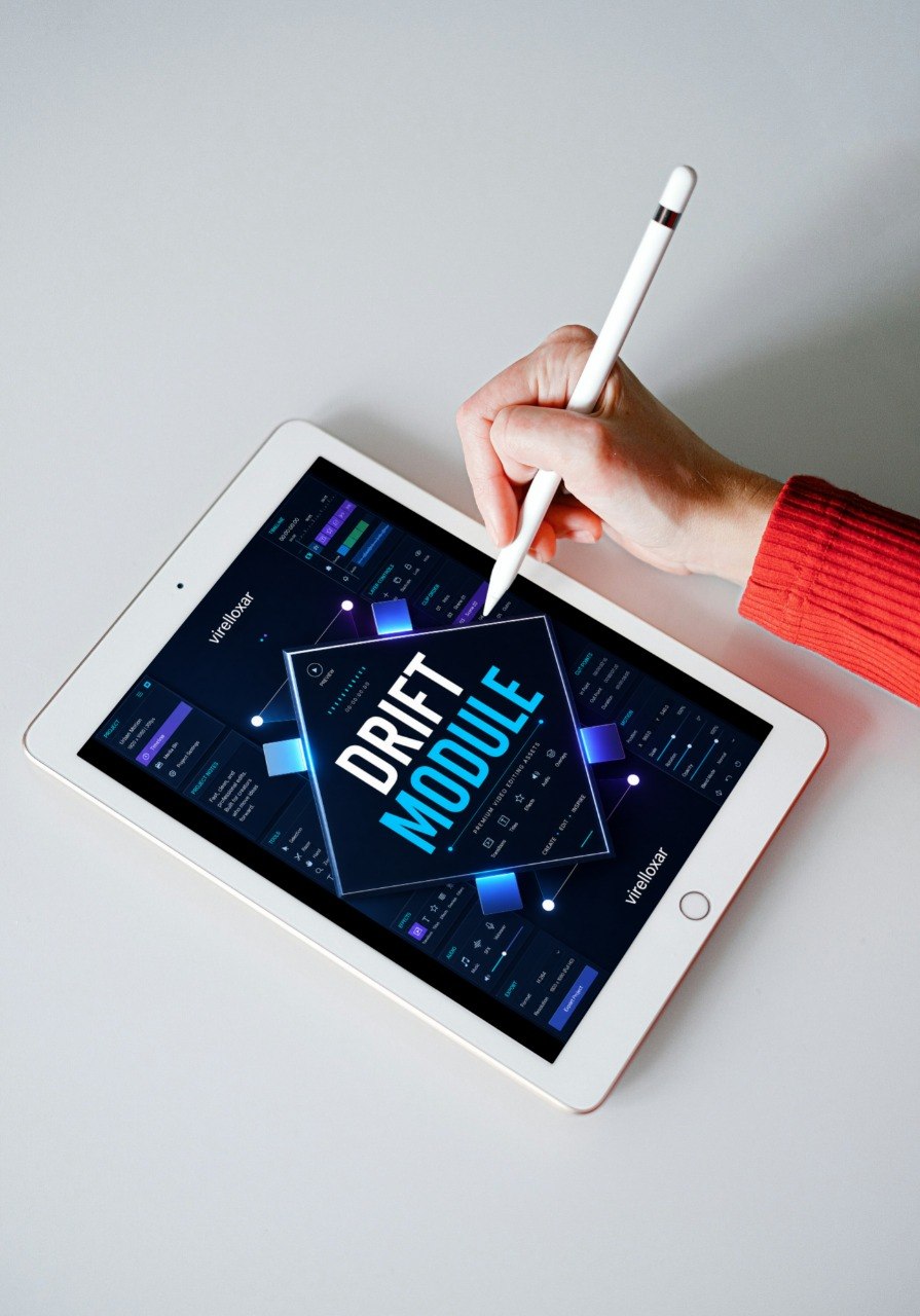 Person using a stylus on a tablet displaying 'DRIFT MODULE' on a light gray background